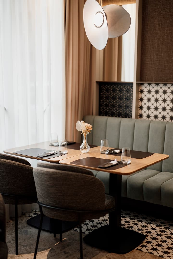 A set table beside an upholstered booth in a modern restaurant